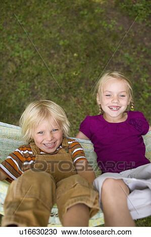 Stock Image - USA, Montana, Whitefish, Brother and sister (6-7) relaxing in hammock. Fotosearch
