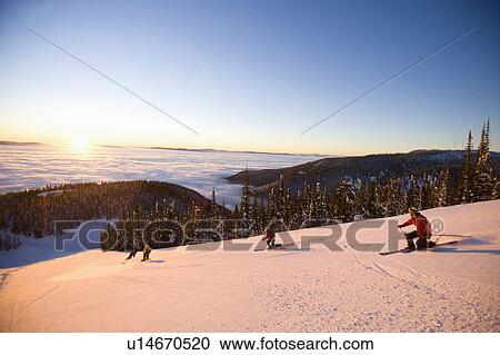 Stock Image - USA, Montana, Whitefish, Four people skiing. Fotosearch