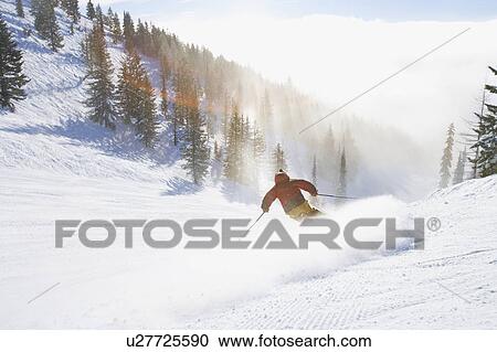 Stock Image - USA, Montana, Whitefish, Male skier on mountain slope. Fotosearch