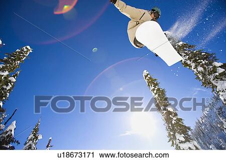 USA, Montana, Whitefish, Young man snowboarding in forest View Large Photo Image Stock Image - USA, Montana, Whitefish, Young man snowboarding in forest. Fotosearch