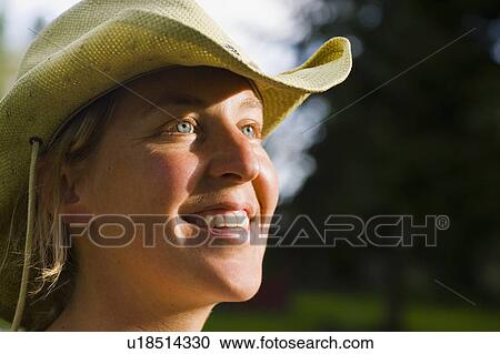 Stock Image - USA, Montana, Whitefish, Young woman wearing cowboy hat. Fotosearch