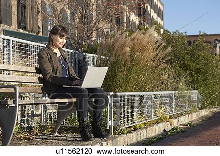 USA, New York City, Brooklyn, woman on bench using laptop View Large Photo Image Stock Image - USA, New York City, Brooklyn, woman on bench using laptop. Fotosearch