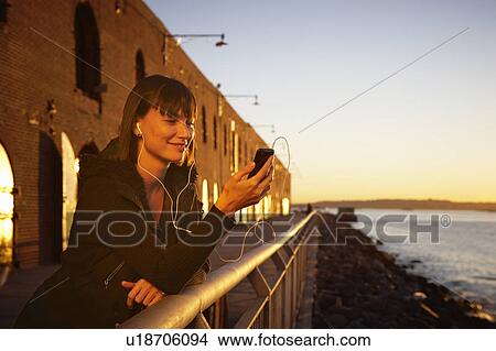 USA, New York City, Brooklyn, woman listening to mp3 player View Large Photo Image Picture - USA, New York City, Brooklyn, woman listening to mp3 player. Fotosearch