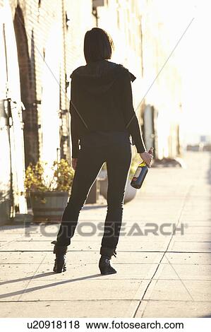 USA, New York City, Brooklyn, woman with bottle standing in street View Large Photo Image Stock Photo - USA, New York City, Brooklyn, woman with bottle standing in street. Fotosearch