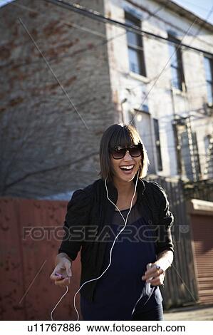 USA, New York City, Brooklyn, woman listening to mp3 player View Large Photo Image Stock Photograph - USA, New York City, Brooklyn, woman listening to mp3 player. Fotosearch