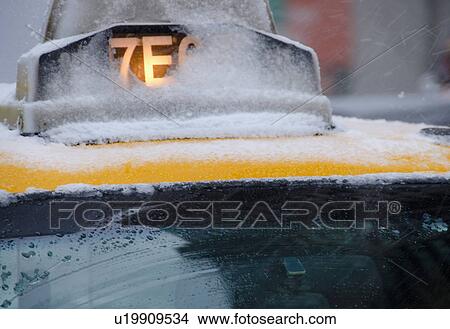 Picture - USA, New York City, Taxi roof covered with snow. Fotosearch