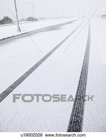 Stock Photo - USA, New York State, Rockaway Beach, tire track in snow on road. Fotosearch