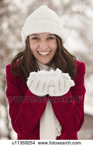Picture - USA, Utah, Lehi, Portrait of young woman holding snow. Fotosearch