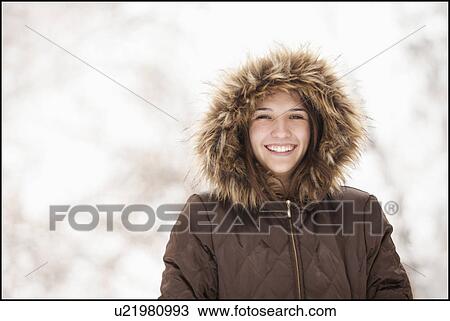 Stock Image - USA, Utah, Lehi, Portrait of young woman wearing winter coat outdoors. Fotosearch