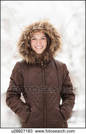Stock Image - USA, Utah, Lehi, Portrait of young woman wearing winter coat outdoors. Fotosearch