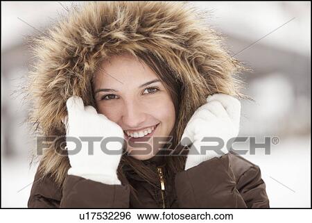 Stock Photograph - USA, Utah, Lehi, Portrait of young woman wearing fur hooded coat. Fotosearch