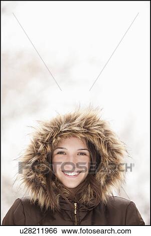 Stock Photograph - USA, Utah, Lehi, Portrait of young woman wearing fur hooded coat. Fotosearch