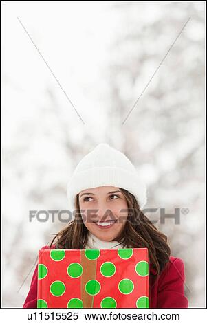 USA, Utah, Lehi, Young woman holding Christmas gift outdoors View Large Photo Image Stock Photography - USA, Utah, Lehi, Young woman holding Christmas gift outdoors. Fotosearch