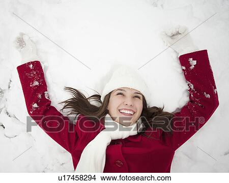 Picture - USA, Utah, Lehi, Young woman lying in snow. Fotosearch