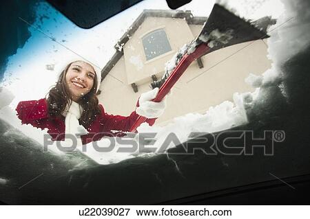 USA, Utah, Lehi, Young woman scraping snow from car windscreen View Large Photo Image Stock Photo - USA, Utah, Lehi, Young woman scraping snow from car windscreen. Fotosearch