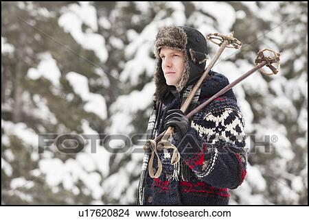 Picture - USA, Utah, Salt Lake City, man carrying ski poles. Fotosearch
