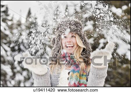 Stock Image - USA, Utah, Salt Lake City, young woman playing in snow. Fotosearch