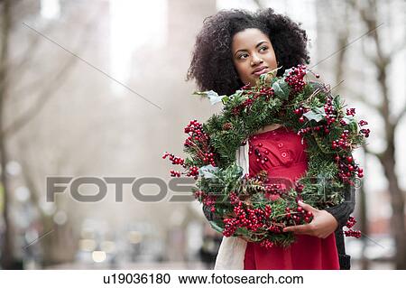 USA, Washington State, Seattle, Young woman holding christmas wreath View Large Photo Image Stock Image - USA, Washington State, Seattle, Young woman holding christmas wreath. Fotosearch