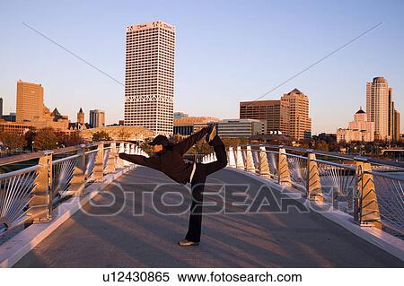 USA, Wisconsin, Milwaukee, Woman doing yoga on bridge in city View Large Photo Image Stock Photography - USA, Wisconsin, Milwaukee, Woman doing yoga on bridge in city. Fotosearch