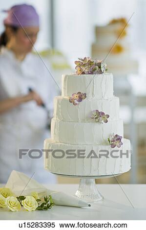 Stock Photography - Wedding cake, pastry chief in background. Fotosearch