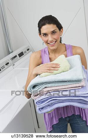 Woman holding stack of fresh towels View Large Photo Image Stock Photo - Woman holding stack of fresh towels. Fotosearch