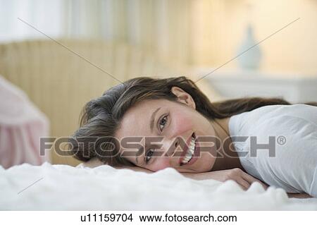 Woman lying in bed View Large Photo Image Picture - Woman lying in bed. Fotosearch
