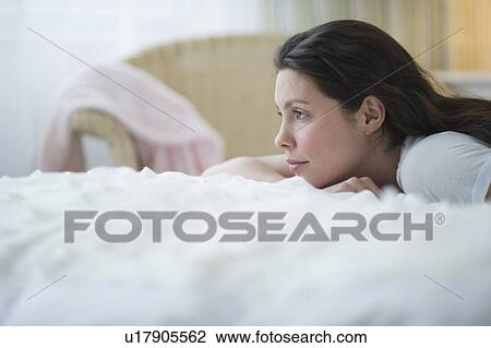 Stock Image - Woman lying in bed. Fotosearch