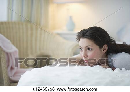 Woman lying in bed View Large Photo Image Stock Photo - Woman lying in bed. Fotosearch
