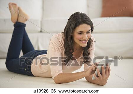 Woman lying on floor using palmtop View Large Photo Image Stock Photograph - Woman lying on floor using palmtop. Fotosearch