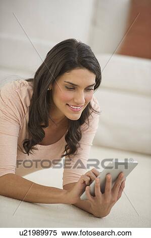 Woman lying on floor using palmtop View Large Photo Image Stock Photography - Woman lying on floor using palmtop. Fotosearch