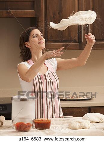 Stock Image - Woman preparing pizza. Fotosearch