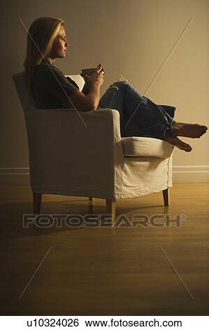 Stock Photograph - Woman sitting in armchair. Fotosearch