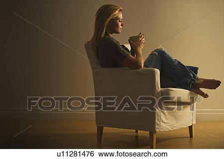 Woman sitting in armchair View Large Photo Image Stock Photograph - Woman sitting in armchair. Fotosearch