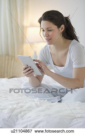 Stock Photo - Woman sitting in bed. Fotosearch