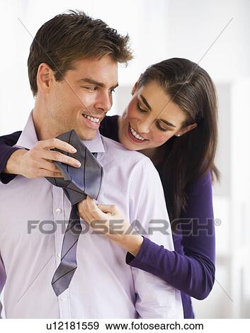 Stock Photo - Woman tying men's tie. Fotosearch