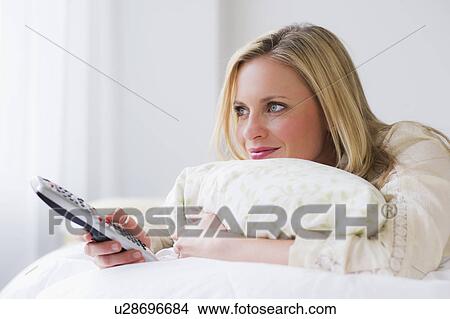 Picture - Woman using remote control. Fotosearch