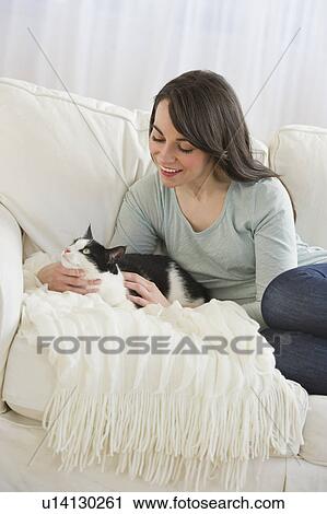 Stock Image - Woman with cat on sofa. Fotosearch