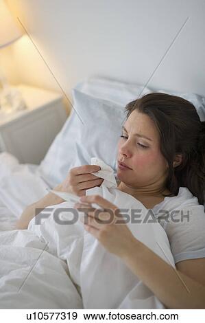 Woman with flu lying in bed View Large Photo Image Stock Photo - Woman with flu lying in bed. Fotosearch