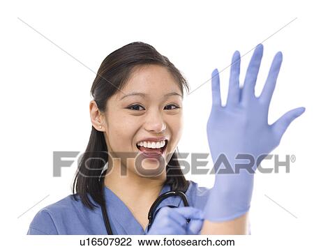 Young cheerful female surgeon putting on protective gloves View Large Photo Image Stock Image - Young cheerful female surgeon putting on protective gloves. Fotosearch
