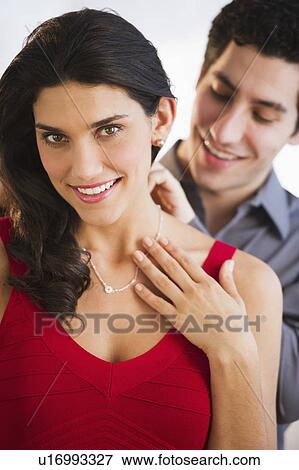 Young couple, man fastening woman's necklace View Large Photo Image Stock Photo - Young couple, man fastening woman's necklace. Fotosearch