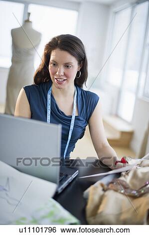 Young fashion designer using laptop View Large Photo Image Stock Photograph - Young fashion designer using laptop. Fotosearch