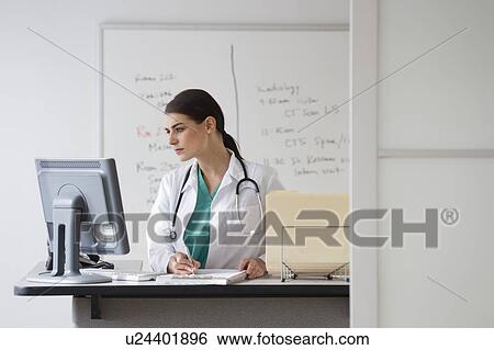 Stock Photograph - Young female doctor working in office. Fotosearch
