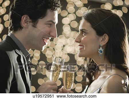 Stock Image - Young happy couple celebrating New Year's Eve. Fotosearch