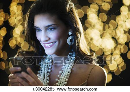 Young woman at party text messaging View Large Photo Image Stock Photography - Young woman at party text messaging. Fotosearch