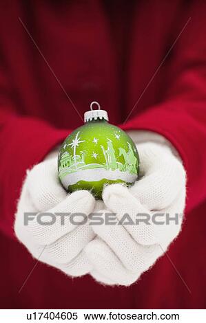 Stock Photography - Young woman holding Christmas bauble. Fotosearch