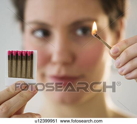 Young woman igniting match View Large Photo Image Stock Image - Young woman igniting match. Fotosearch