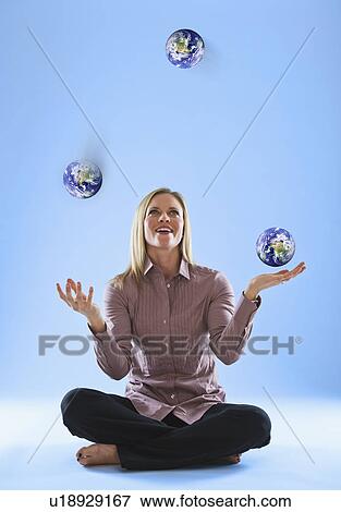 Young woman juggling globes in clouds View Large Photo Image Stock Photo - Young woman juggling globes in clouds. Fotosearch