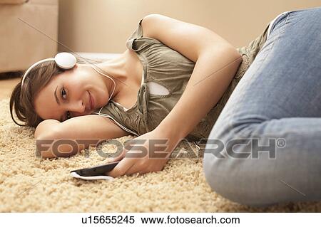 Stock Photography - Young woman listening music from mp3 player. Fotosearch