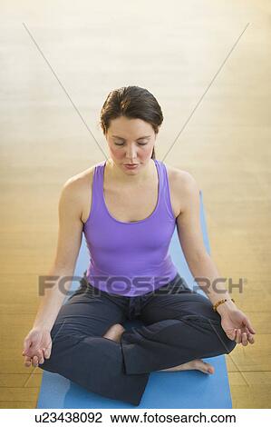 Stock Image - Young woman meditation in lotus position. Fotosearch
