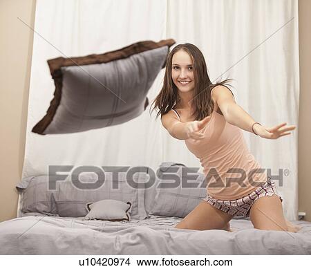 Picture - Young woman pillow-fighting. Fotosearch